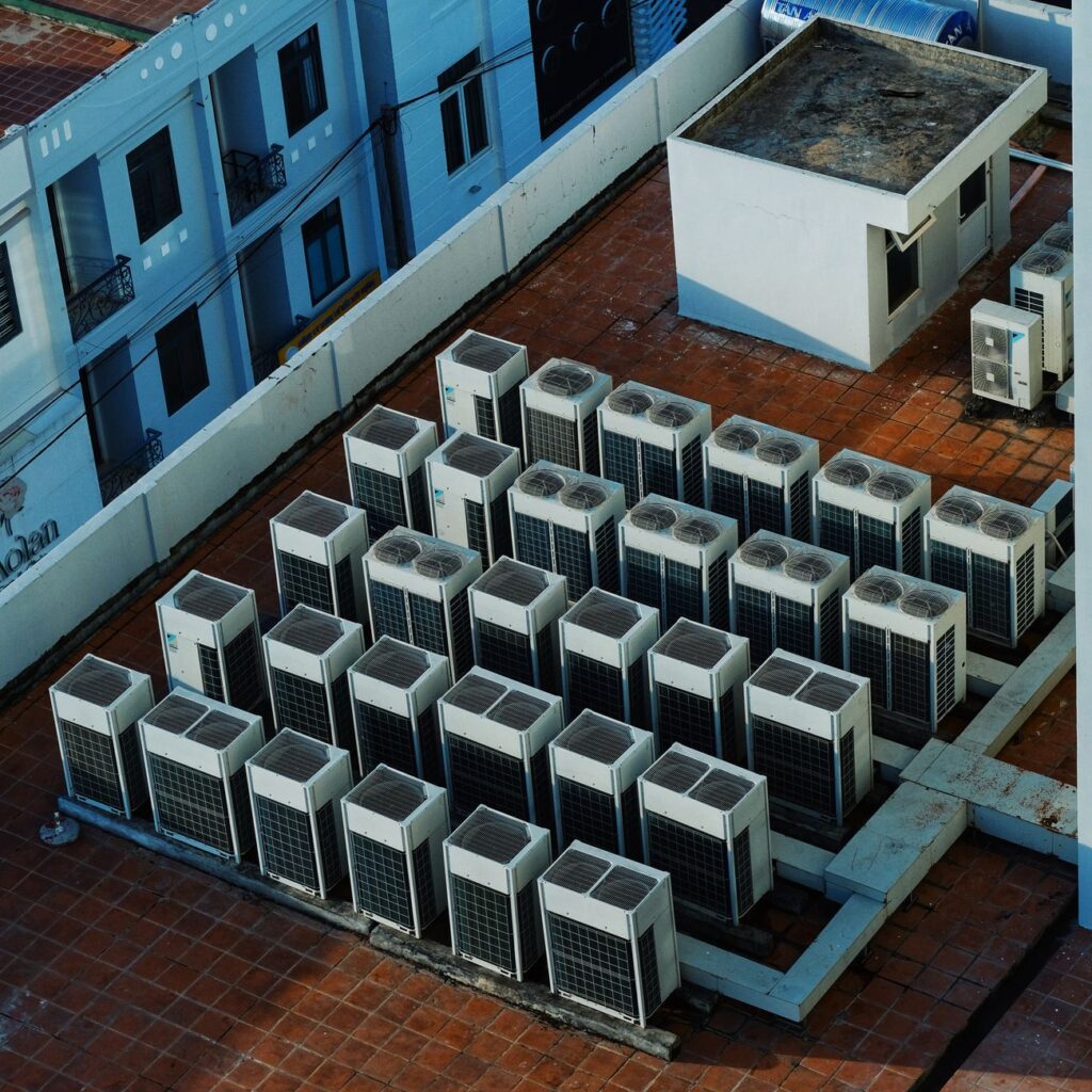 HVAC contractor installing a commercial air handling unit on a rooftop in the USA, safety equipment and tools visible