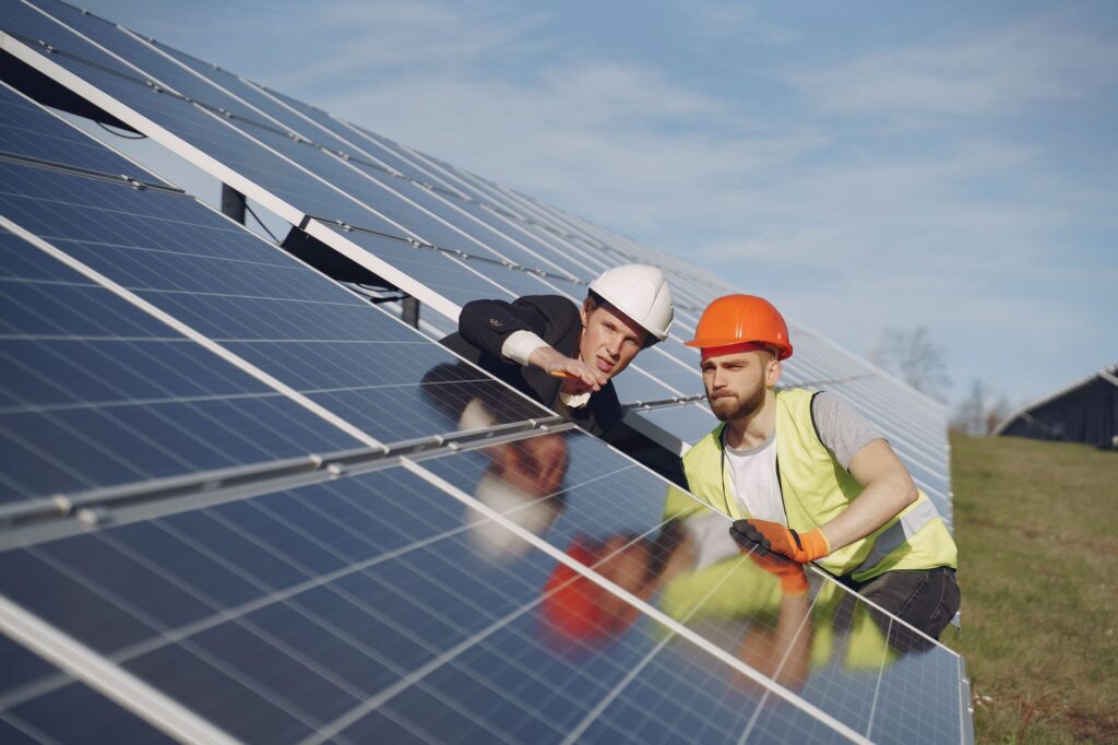solar installer shaking hands with homeowner in front of newly installed solar panels