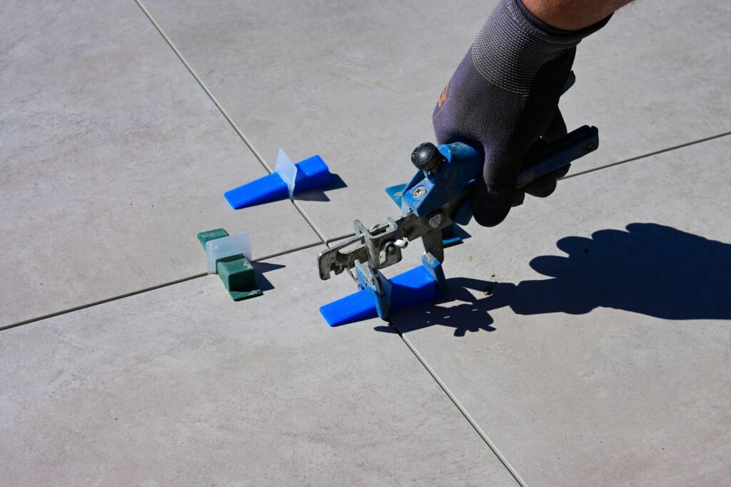 Tiler's professional tools laid out neatly on a job site, tile saw and hand tools visible