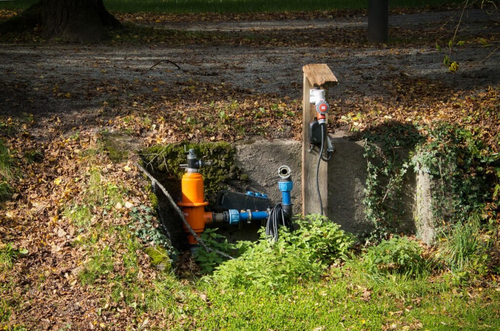 Landscaper installing an irrigation system in a garden, professional equipment in foreground
