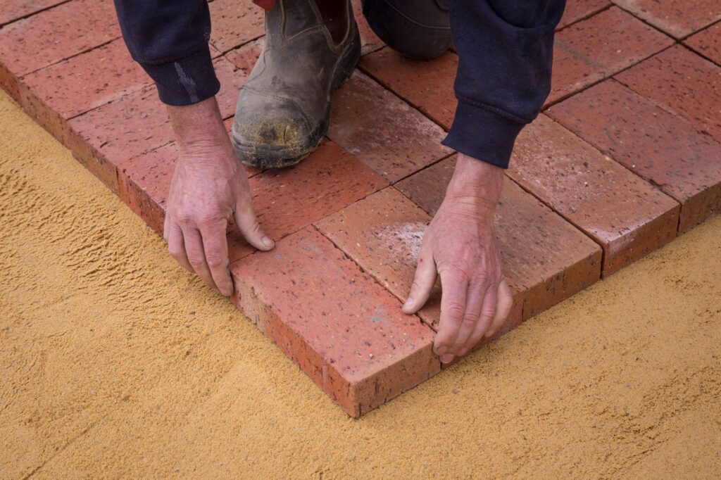 Bricklayer contractor discussing job pricing with a client at a US job site, professional appearance and tools visible