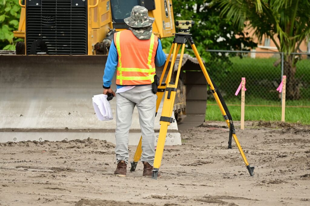 Groundworker contractor discussing job pricing with a client at a US job site, professional appearance and tools visible