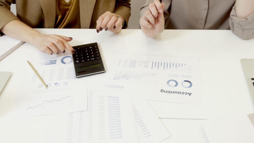 A contractor reviewing an accounting dashboard showing project costs, payments received, and outstanding invoices