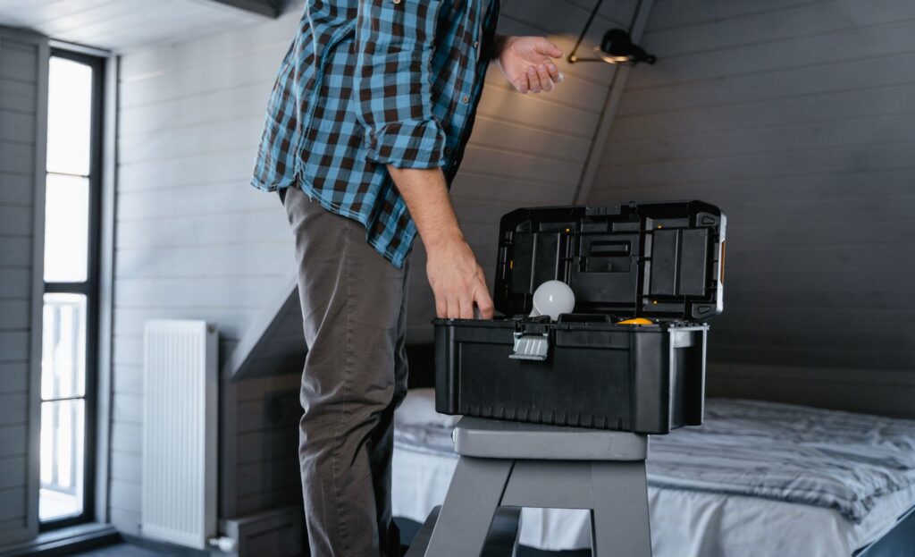 US handyman with toolbox and smartphone on a residential job site, professional appearance and branded uniform