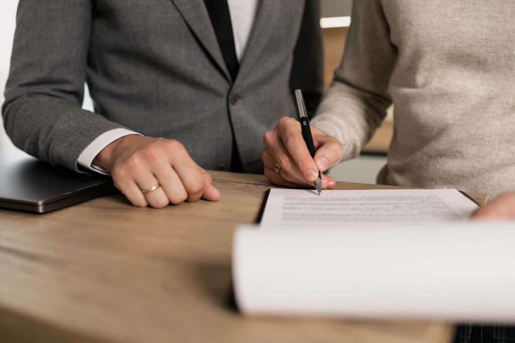 US contractor and client signing a construction contract at a kitchen table