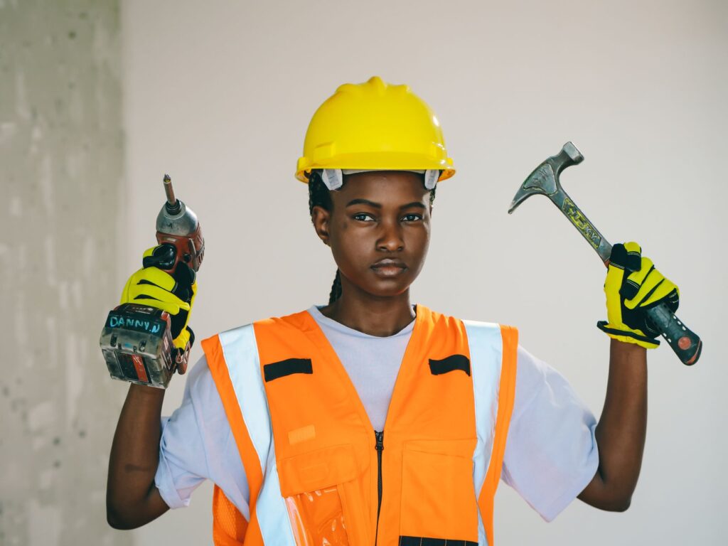 A group of female apprentices in safety equipment on an electrical training site, an instructor pointing at equipment