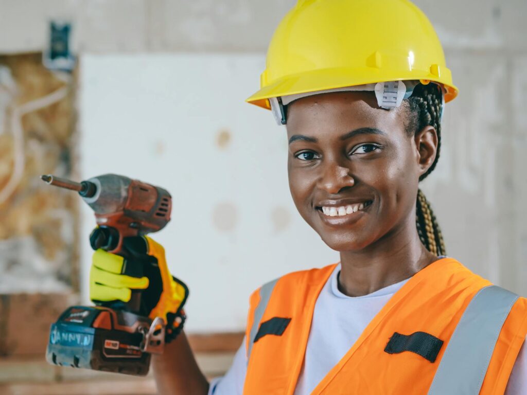 A female electrician confidently working on a commercial electrical installation, professional workwear and tools